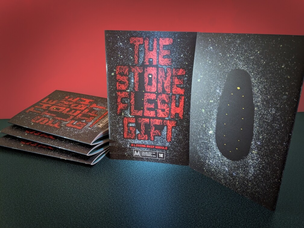 Promo photo of multiple physical proof copies of The Stone-Flesh Gift, showing the front and back covers.