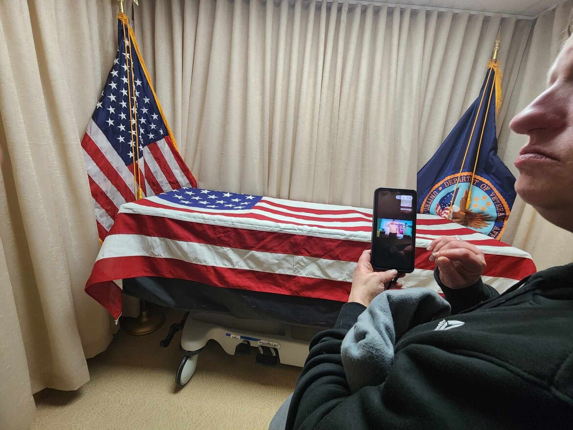 Crystal at the VA Hospital with her father's casket with a flag over it - his final salute