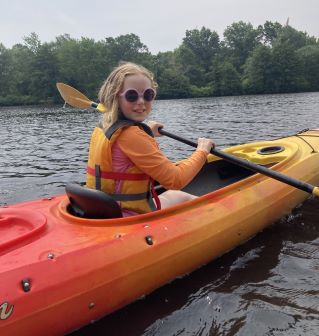 young girl paddling a kayak