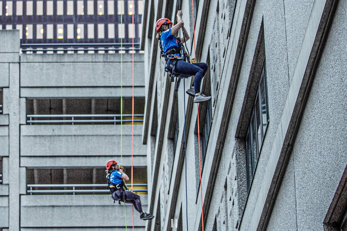 Two women climbing up a 17 story building