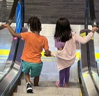 two children holding hands on a field trip in a museum