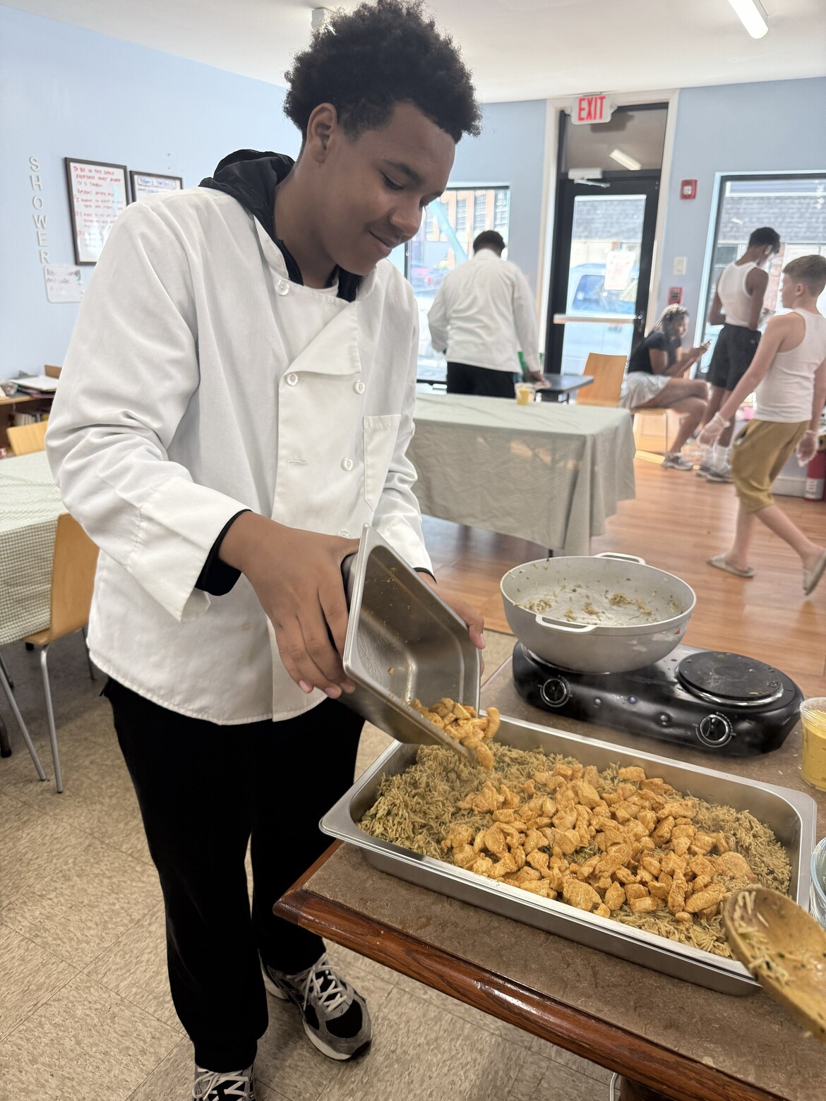 Teen participant with tray of cooked chicken
