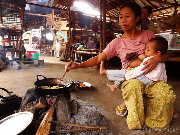 Multitasking at its best: A Kachin mother seen cooking meals for her family while breastfeeding her child.