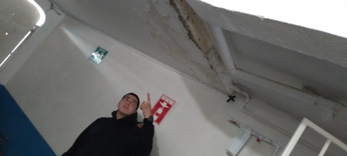 Moises points out ceiling damage caused by leaks in the garage/tenasa area.