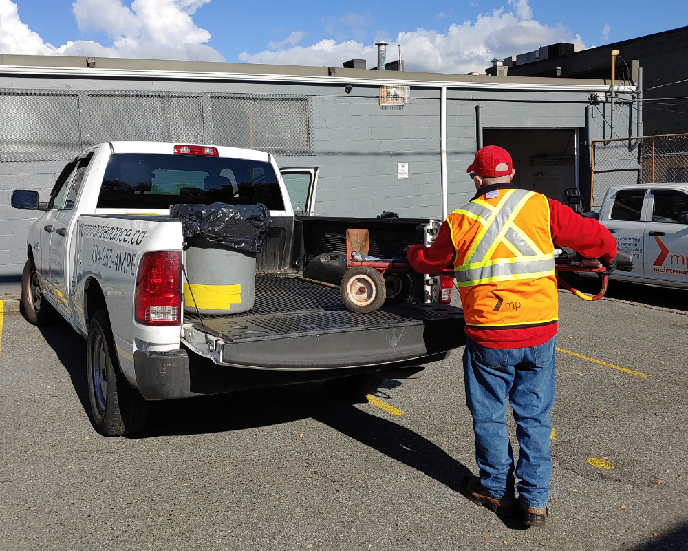An associate loads their micro-cleaning trolley into a pick up truck.