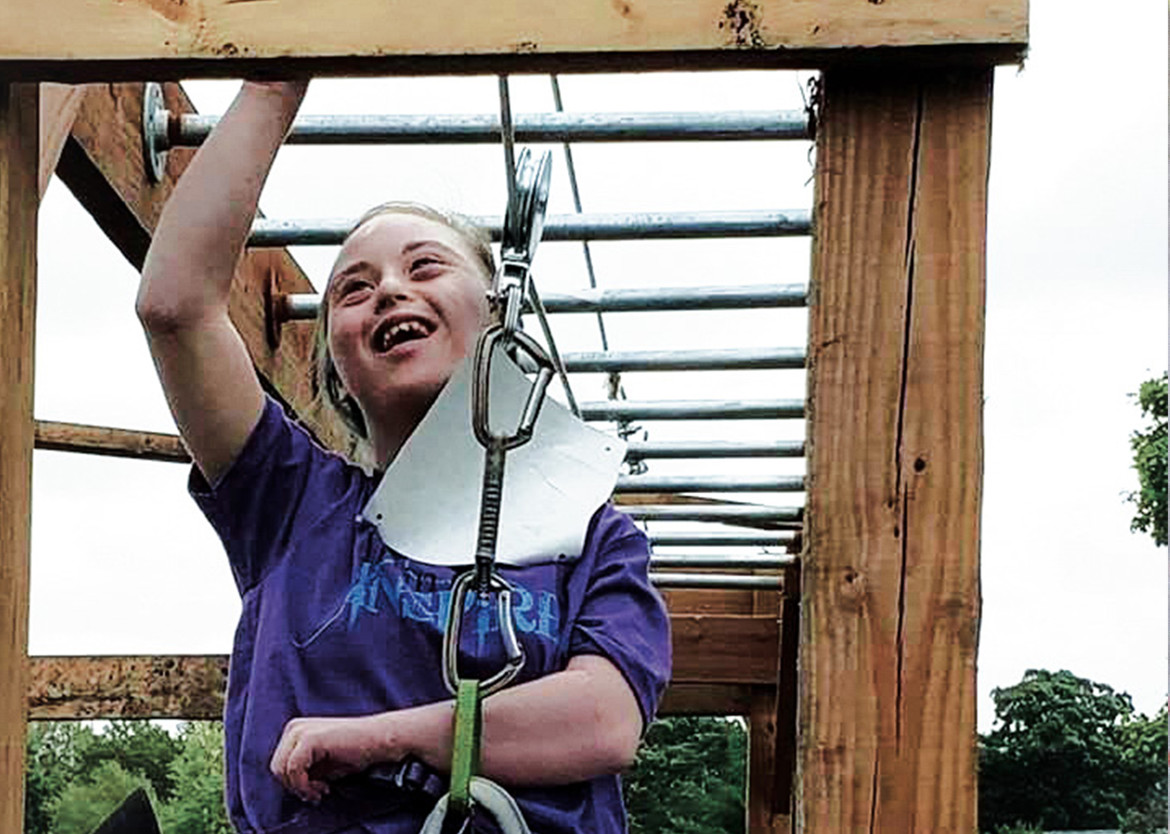 Female Train to Inspire participant doing accessible monkey bars