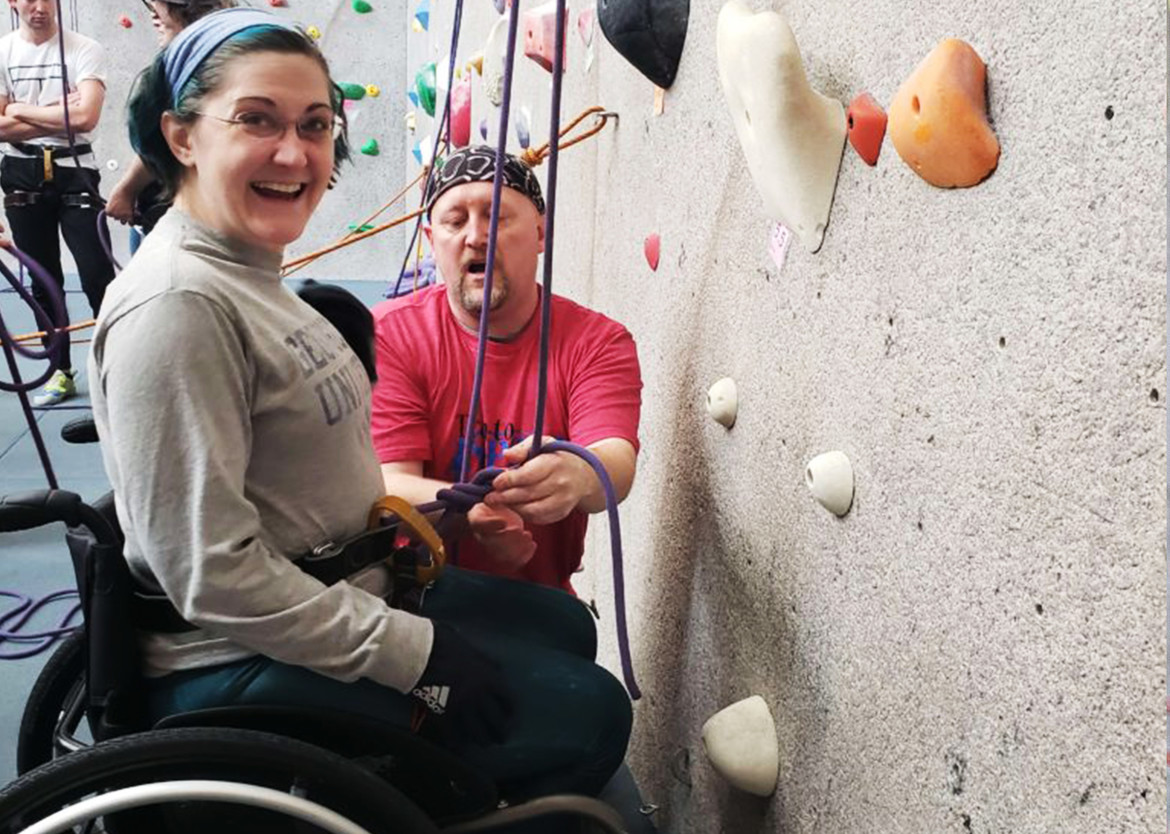 Woman in wheelchair getting ready to rock climb
