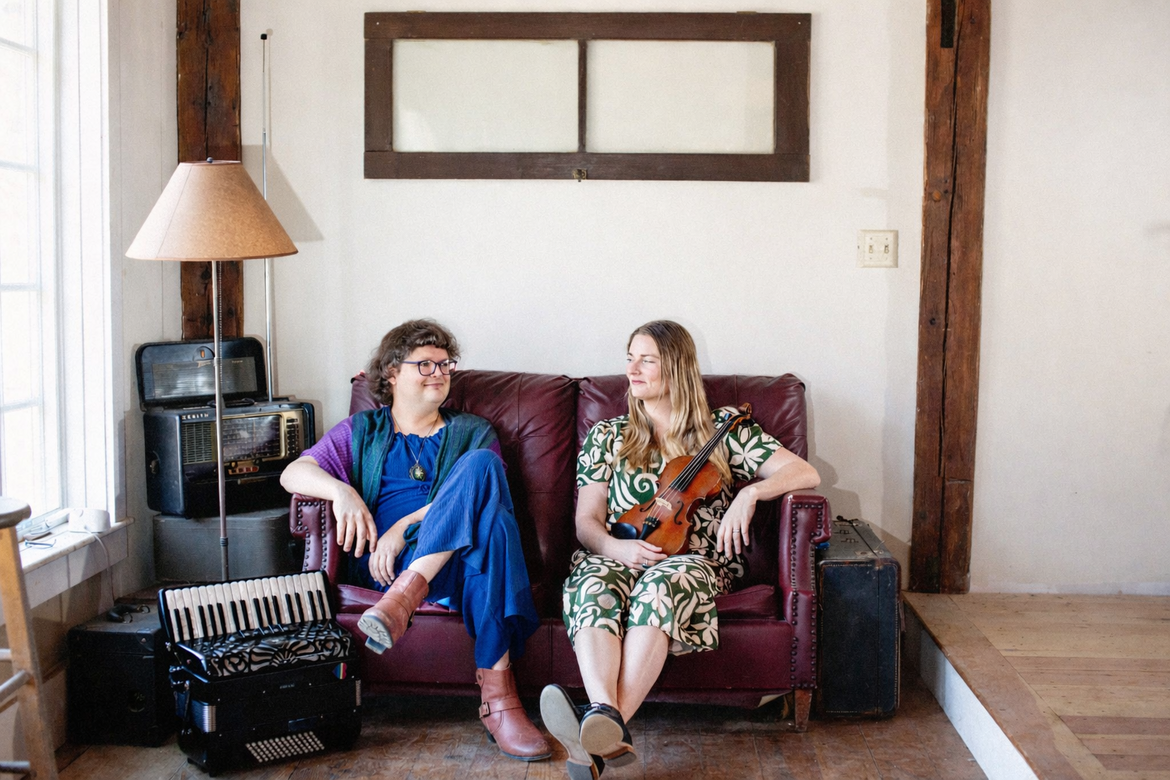 Alex and Audrey sat on a crimson sofa