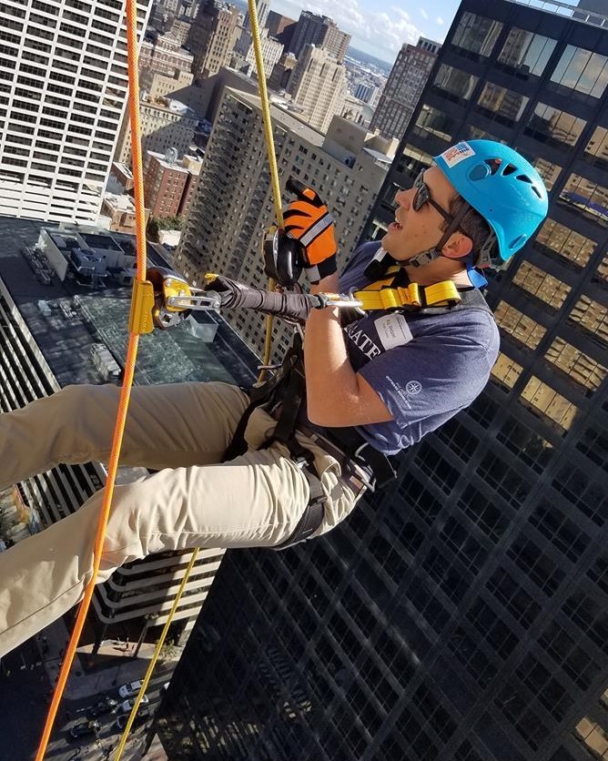 Man repelling down a building
