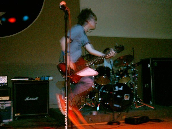 Jacob Burns jumps in the air with his bass guitar during a Rock n' Roll for Dummies show