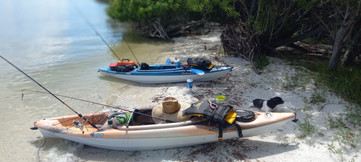 Kayaks and fishing poles on the beach of the island my fiancé and I kayaked to