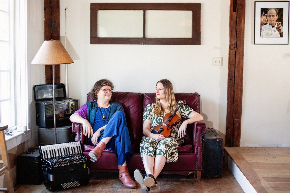 Alex and Audrey sat on a crimson sofa